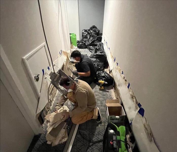 SERVPRO employees set up equipment in the hallway of a commercial property